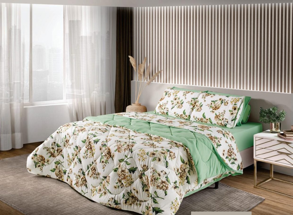 Edredom estampado floral verde sobre cama de casal
